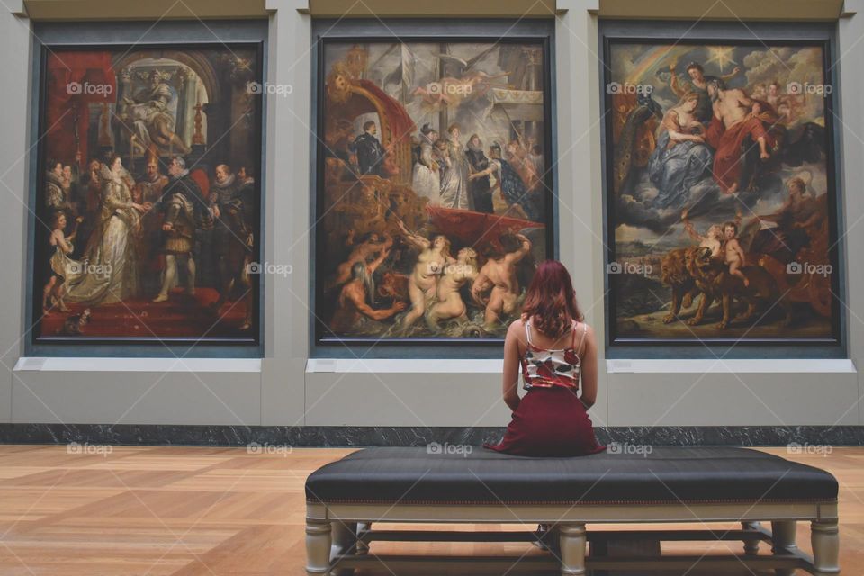 A girl sitting inside an art museum.