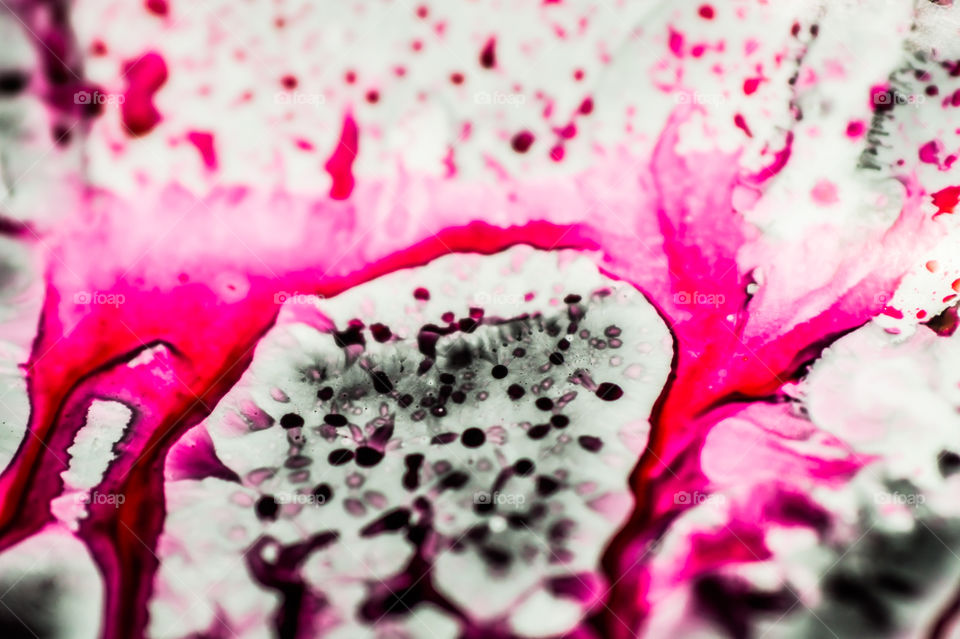 Black and pink refill ink spilled onto the white sink and the ink mixed into abstract blobs and patterns.