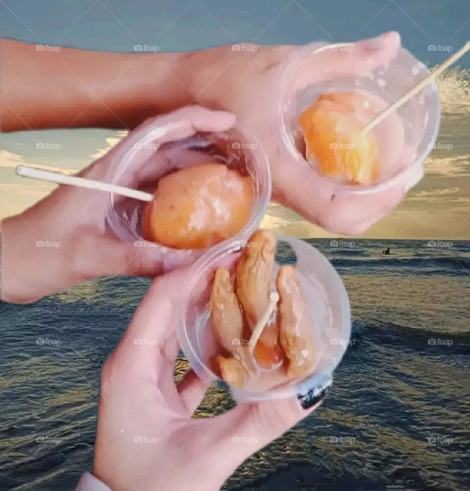 Ice cream is being enjoyed with friends on a sea beach.