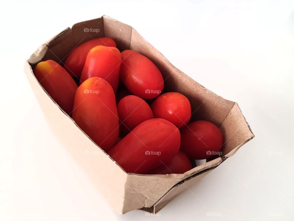red organic tomatoes in a
 recyclable cardboard box