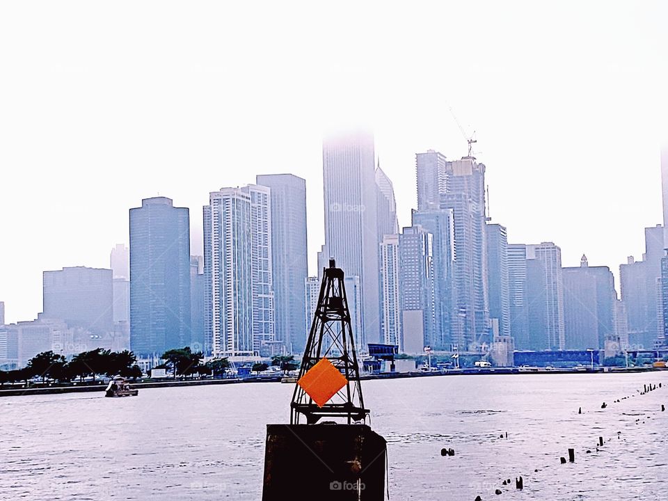 View of foggy downtown Chicago from Lake Michigan and a steel buoy