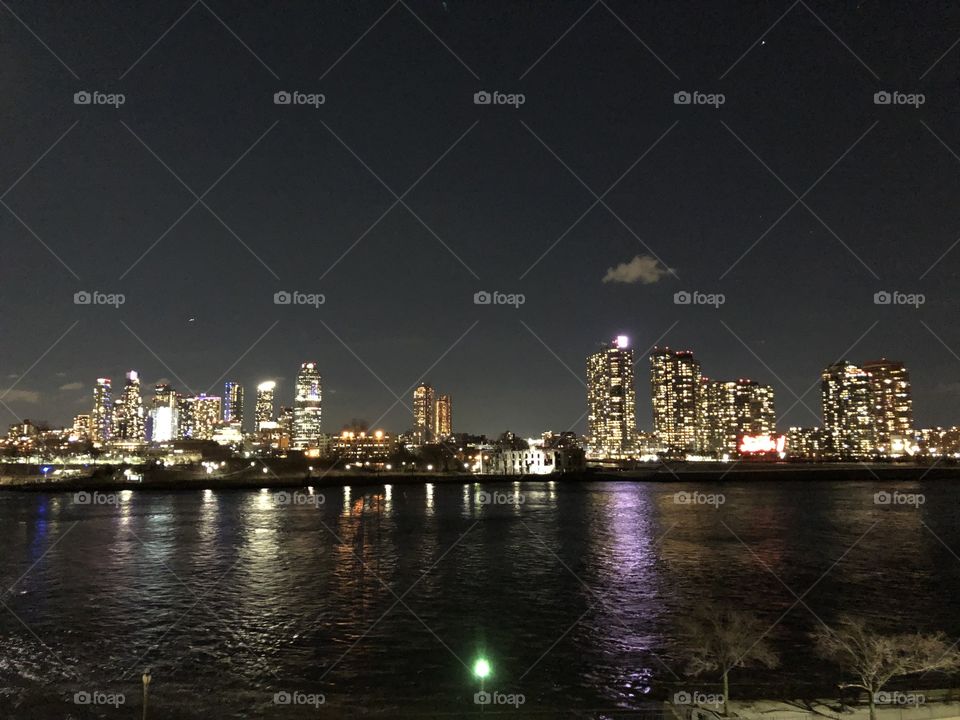 Beautiful view of Jersey city from the edge of New York City taken at night with city lights and the Hudson River 