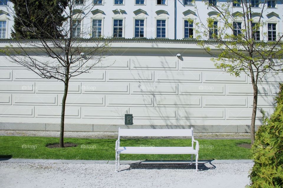 White bench, white wall, park, Prague.