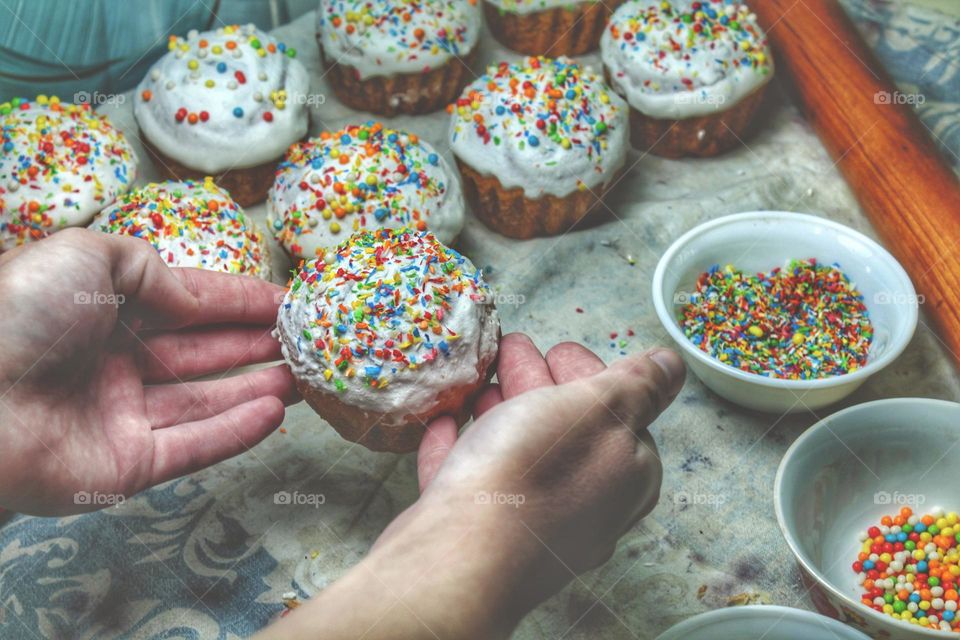 baking muffins for a holiday dinner. White icing on the cake is sprinkled with colored confectionery topping. Close photo on the theme of Easter and the resurrection of Jesus Christ.