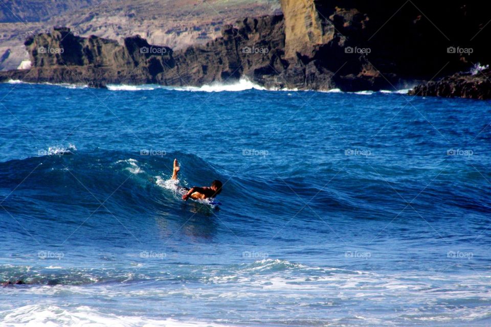 A surfer catching a wave on the open sea in Hawaii