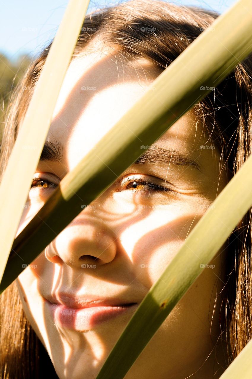 Close-up portrait of a girl. A girl with her hair tied up is caught in the light.