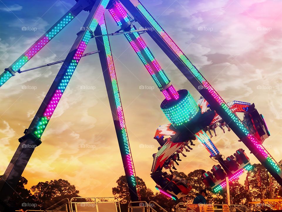 Thrilling carnival ride during a golden sunset.