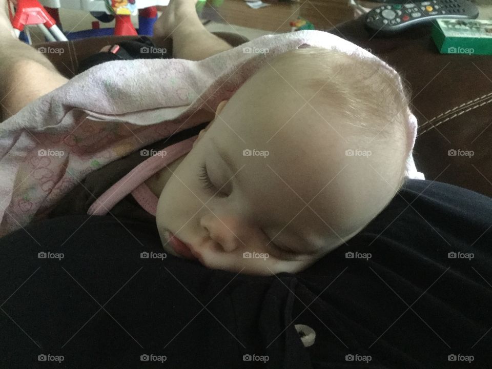 Baby girl with Down syndrome sleeping over shoulder