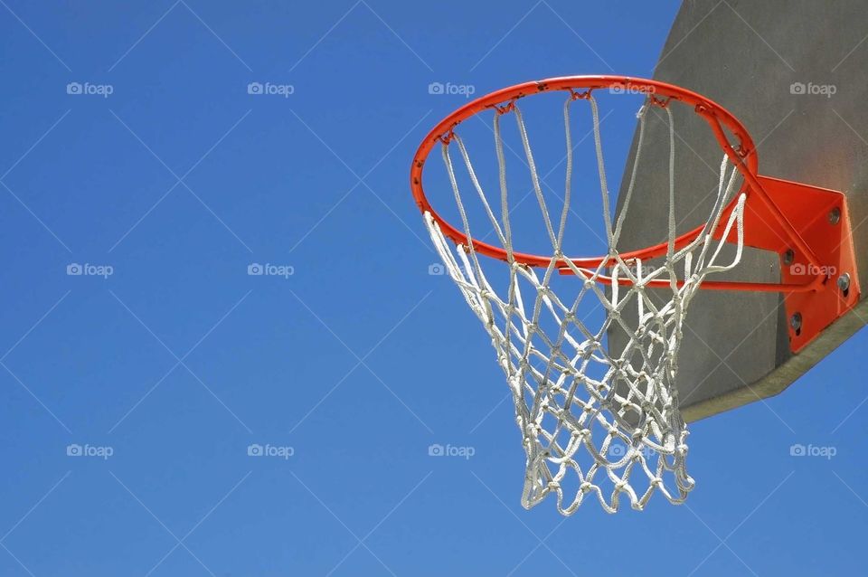 Basketball hoop against a blue sky.