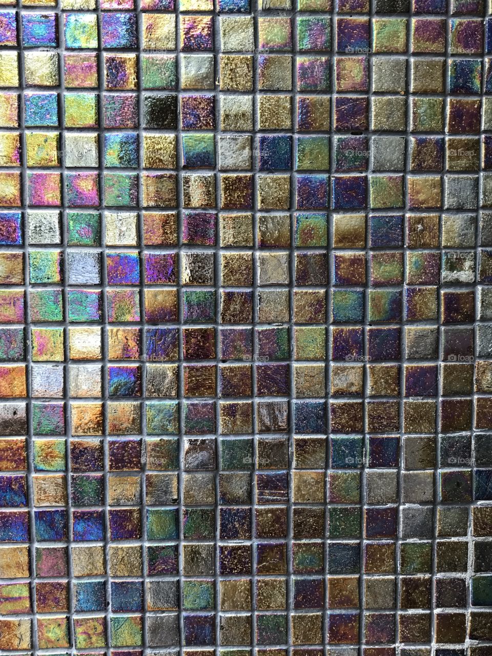 Old, shiny, jewel-toned mosaic tile wall