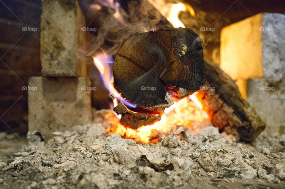 piece of wood burning in the fireplace