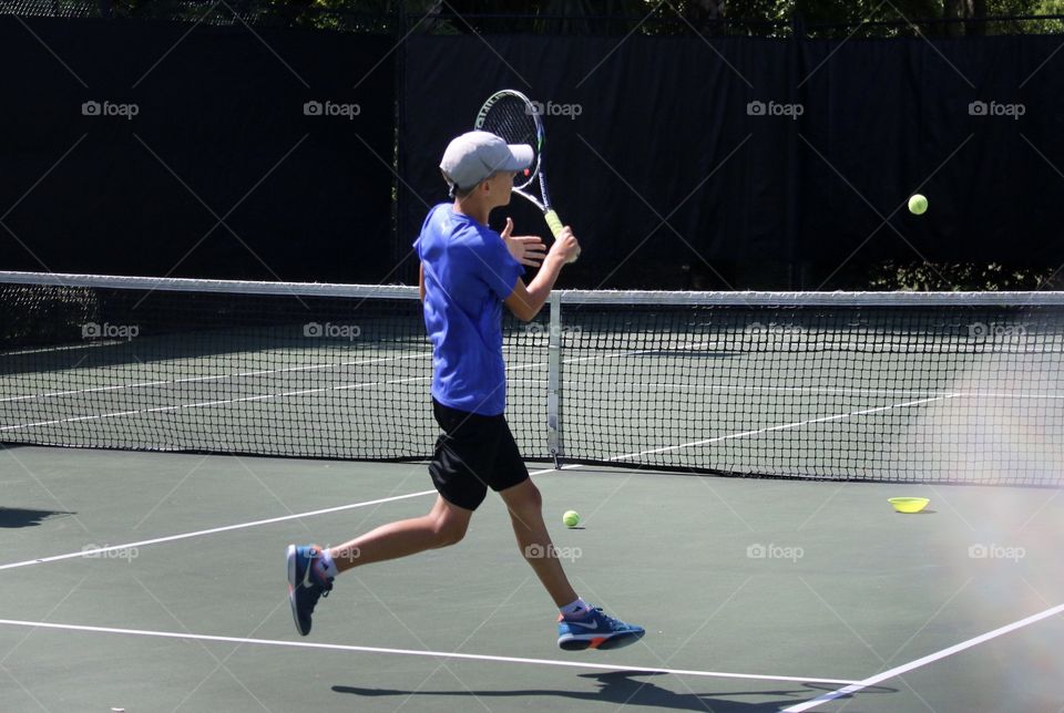 Hitting the ball and jumping at tennis practice