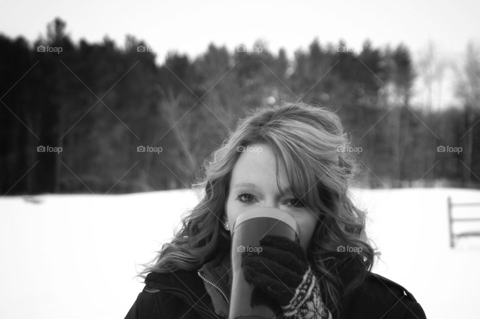 Woman drinking coffee on snowy landscape