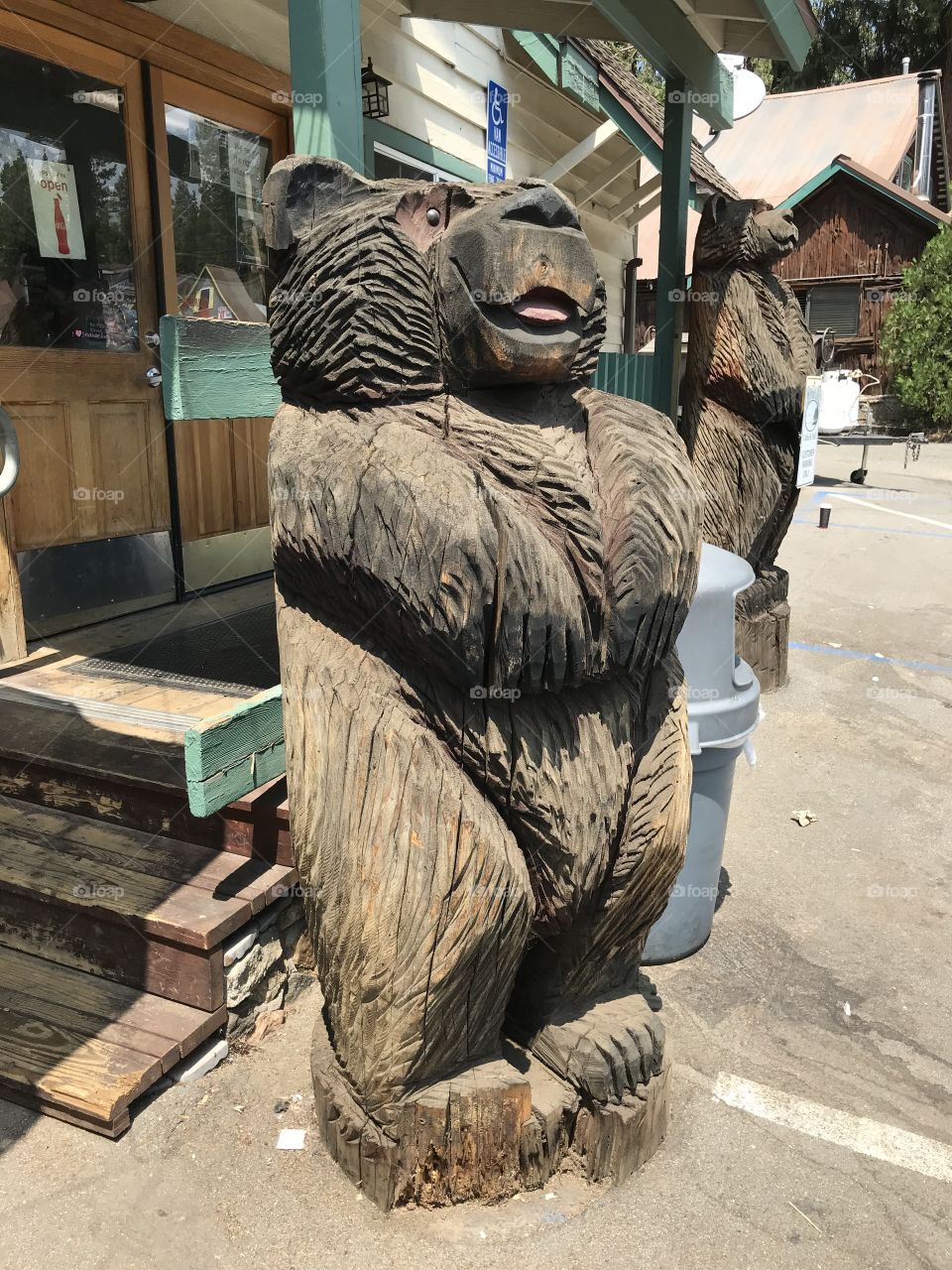 Two standing wooden bears guarding the coffee and deli shop at all times.