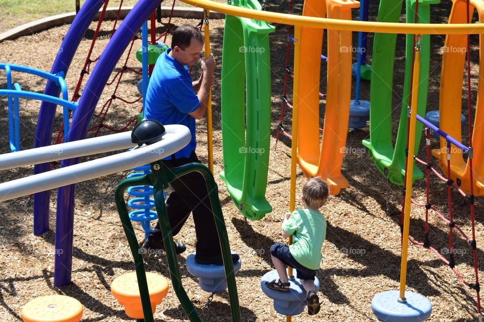 A boy and his dad playing at the park 