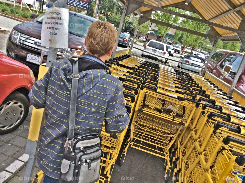 Shopper returning a grocery cart. Shopper returning a grocery cart in parking lot