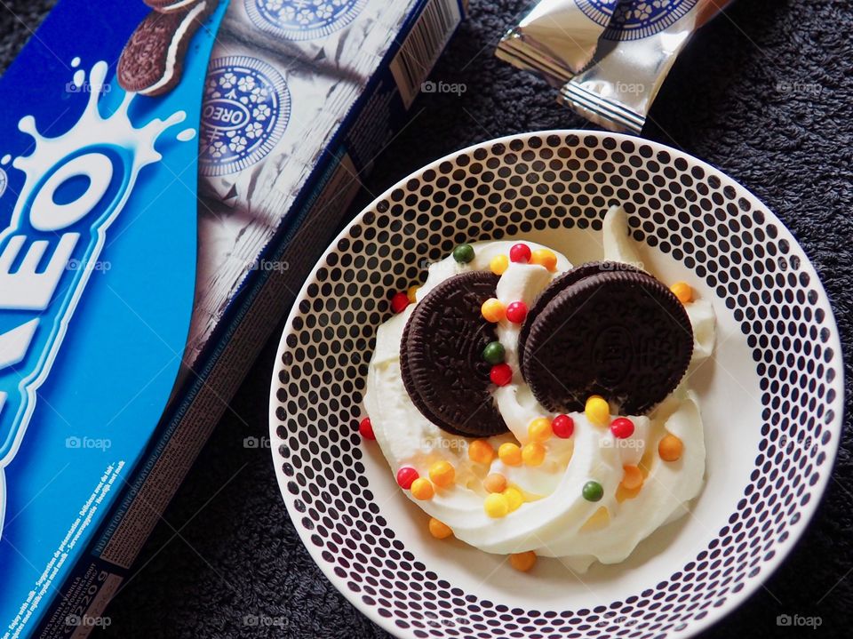 Oreo cookies with whipped cream and sprinkles.