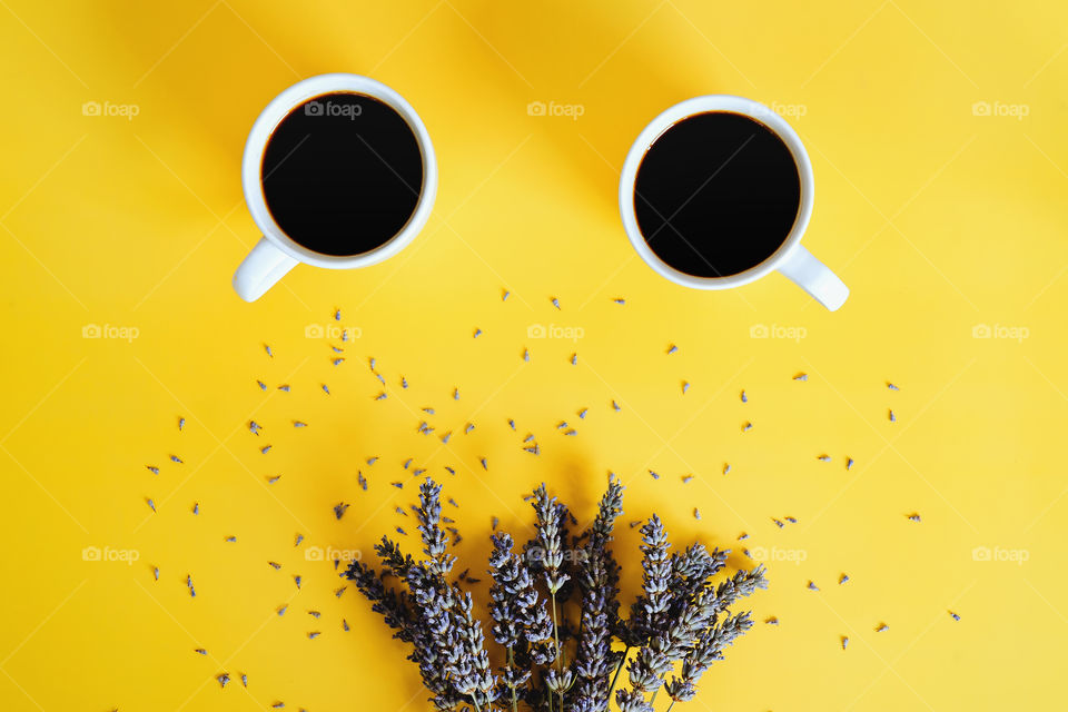 Business working morning with cup of hot coffee, lavender flowers on yellow background close up. Top view, copy space, flat lay, mockup.