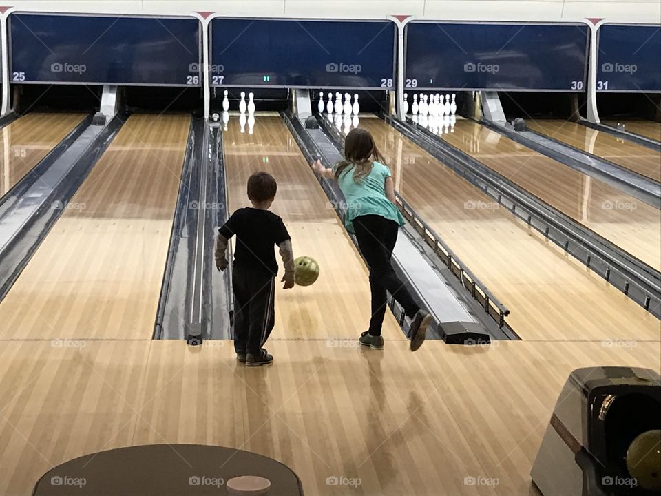 Siblings learning bowling