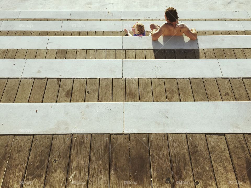 High angle view of two people sitting on wooden steps