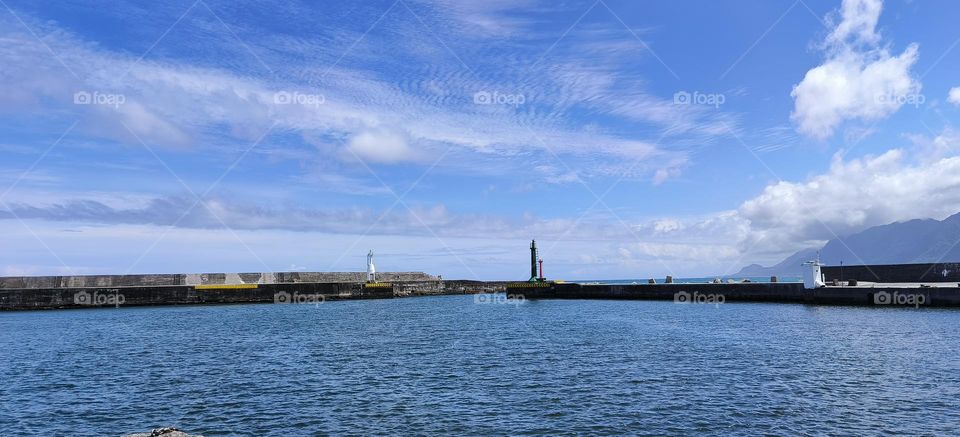 Lighthouse and blue sky with white clouds