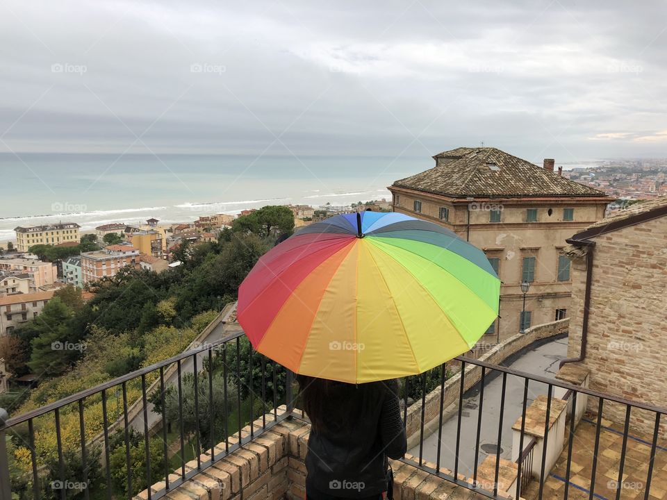 Girl from a beautiful landscape with a multi colored umbrella