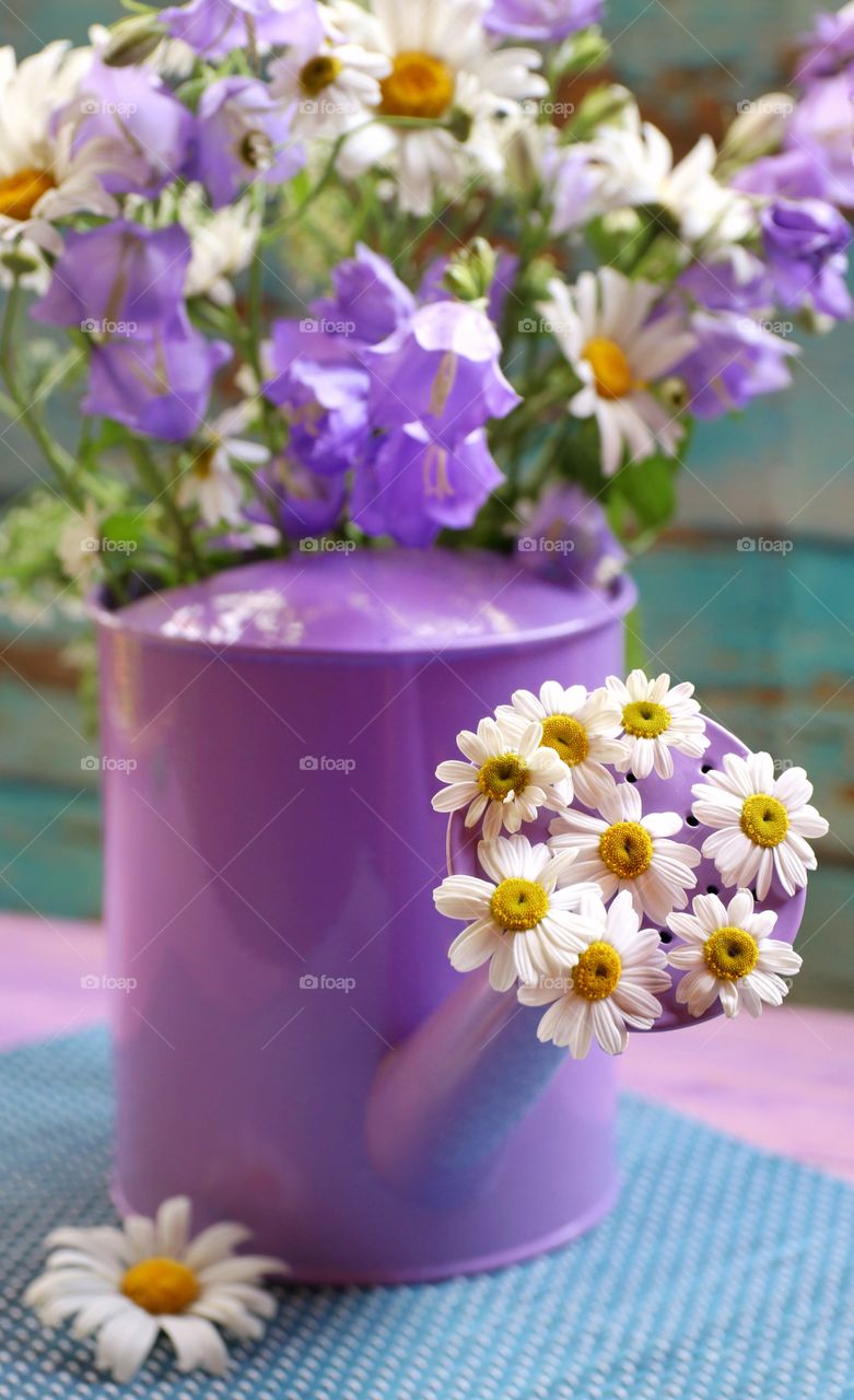 summer wild flowers in a purple watering can