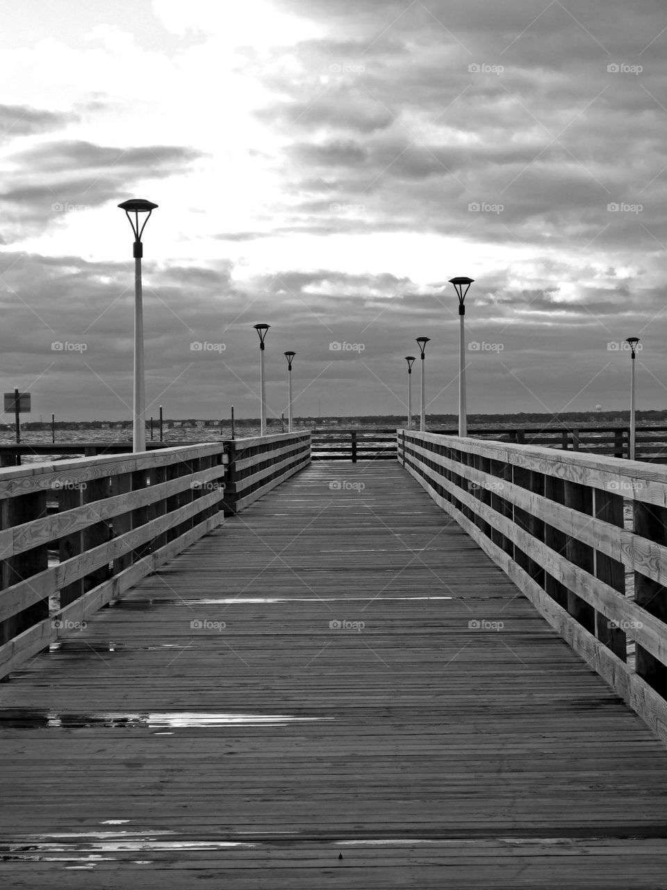 
Symmetry - A forward view of a rain soaked fishing pier which is reaching out into the bay, on a cloudy, overcast day