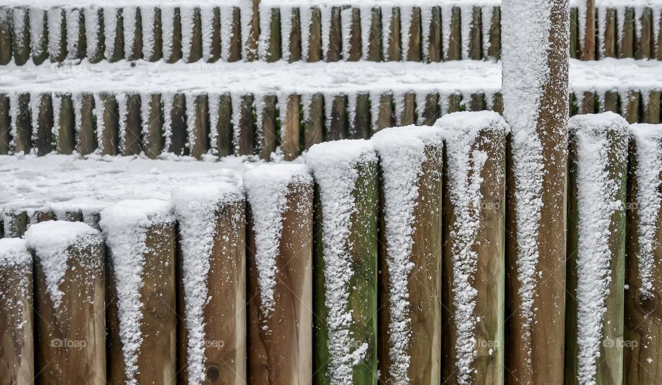 A dusting of snow over wooden fence posts