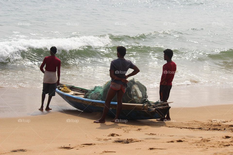 This picture describes fishermen waiting when the tides calm a little bit then they go inside the sea for fishing.