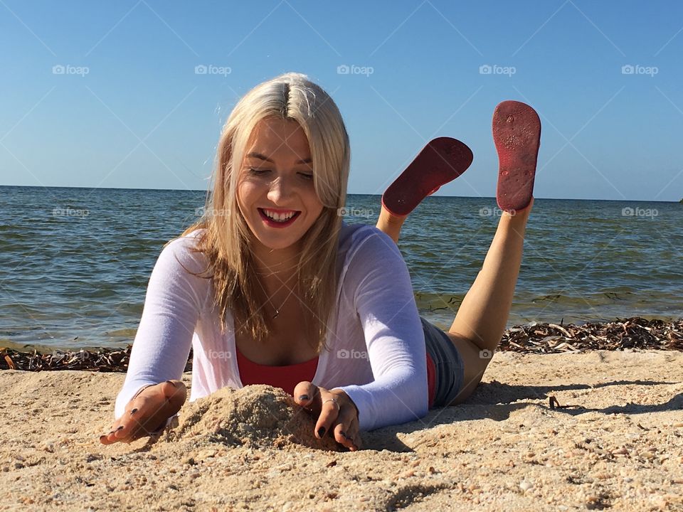 Woman lying on sandy beach