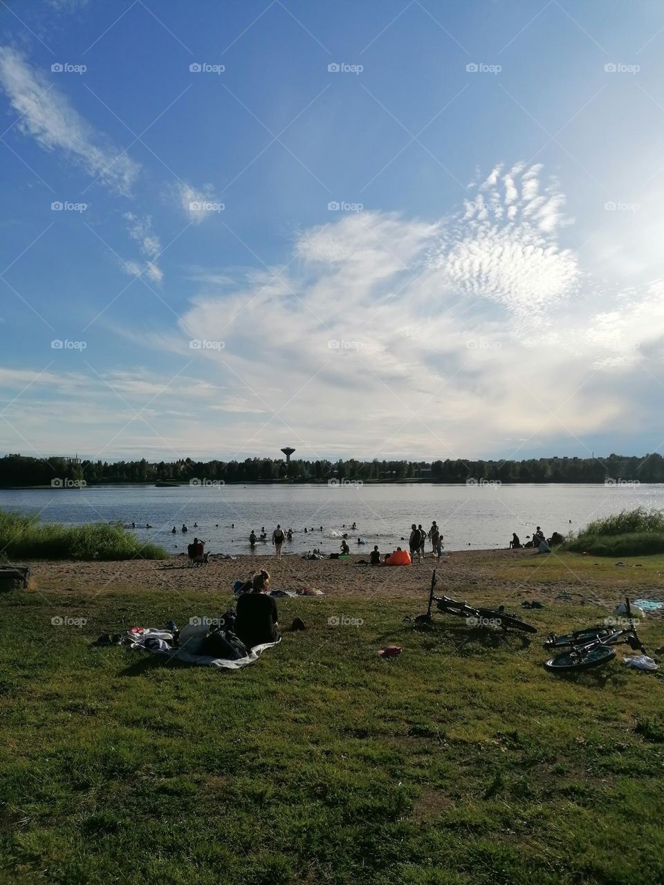 People swimming on a Finnish beach on a warm summer day