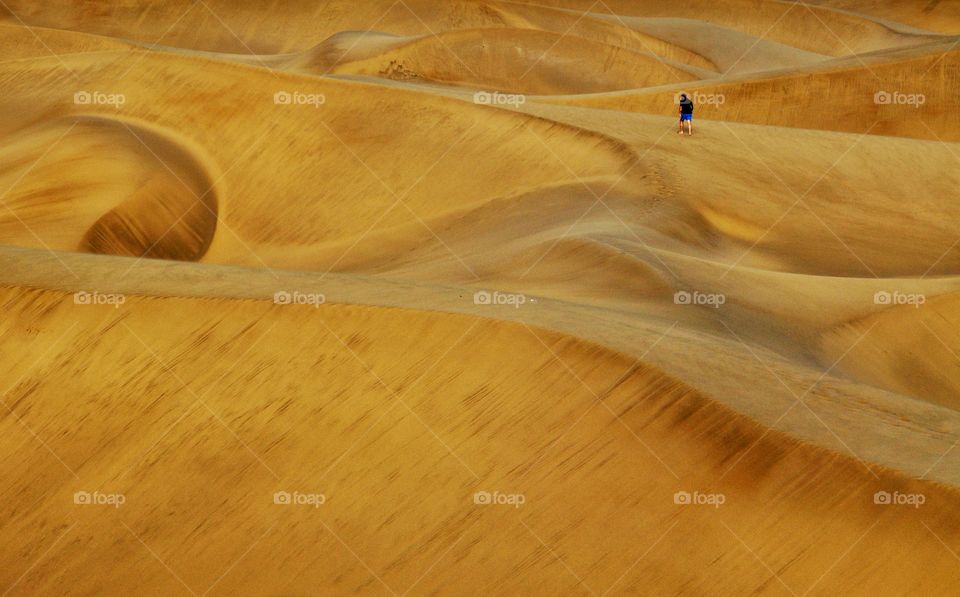 man walking in sandy dunes of maspalomas on gran canaria island in Spain