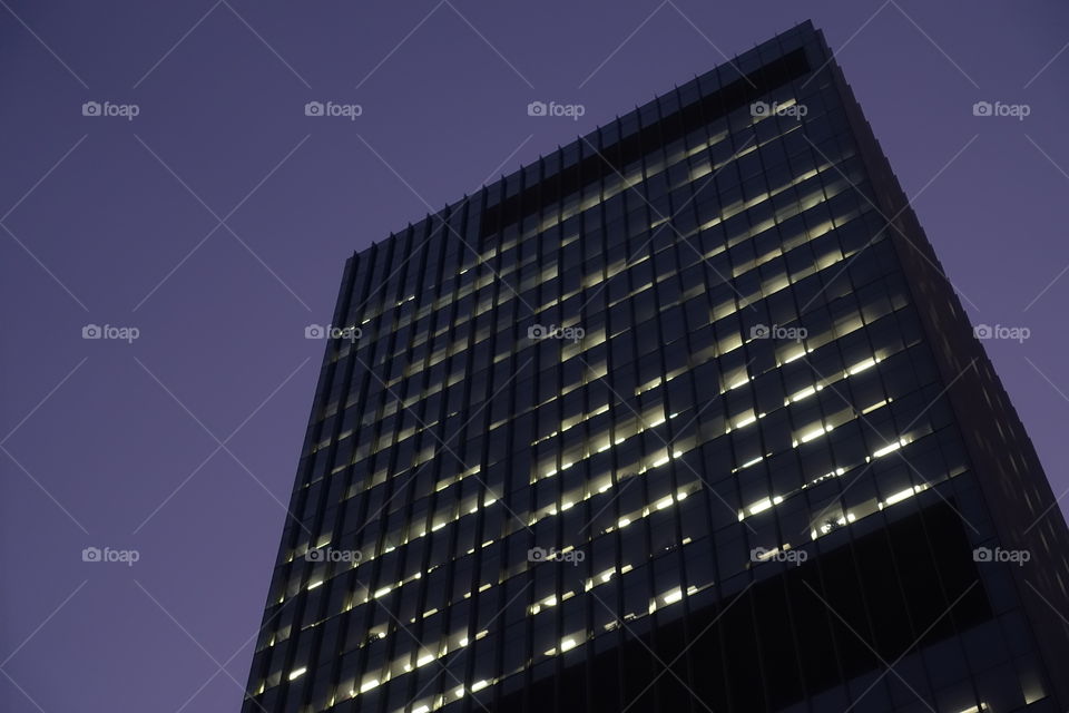 A view of skyscraper with purple sky.