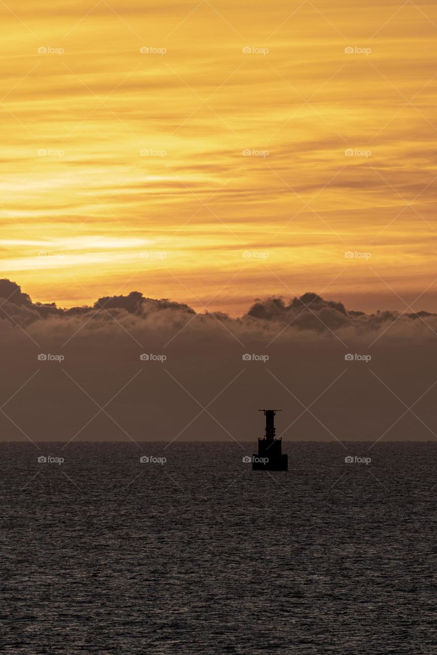 sunrise in the baltic sea and a floating lighthouse