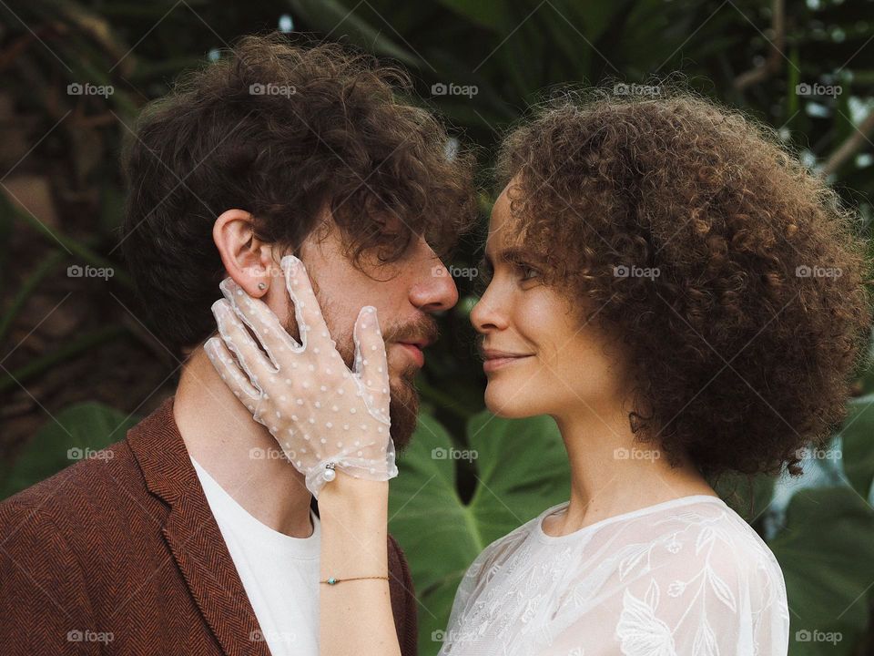 Young beautiful lovers in botanical garden 