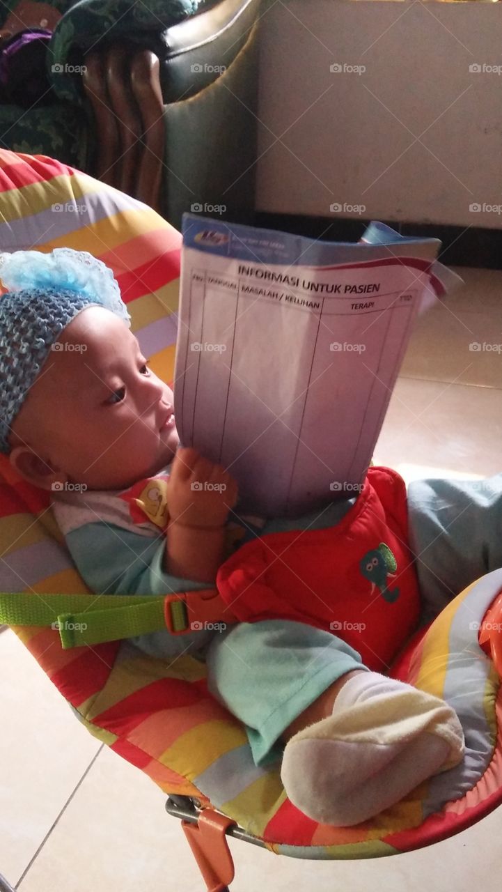 The baby is reading a health information book