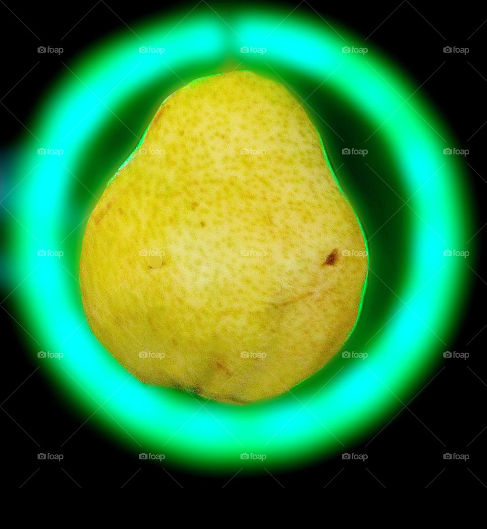 A green pear in a neon circle whose borders are indistinct