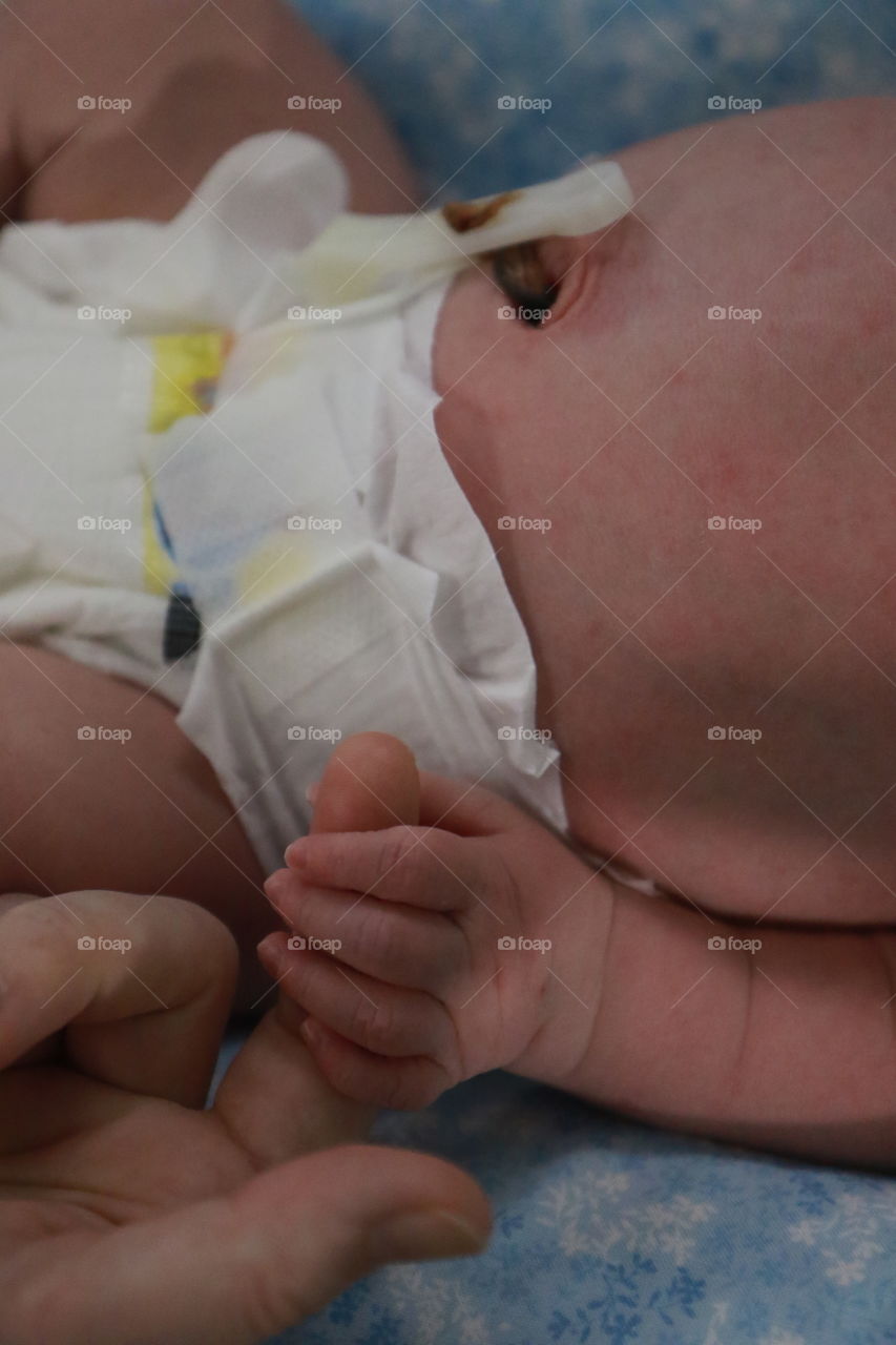 Holding hands with a newborn in a humidicrib