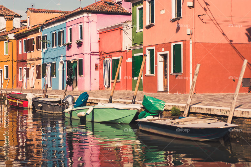 The colorful city of burano Italy with boats docked 