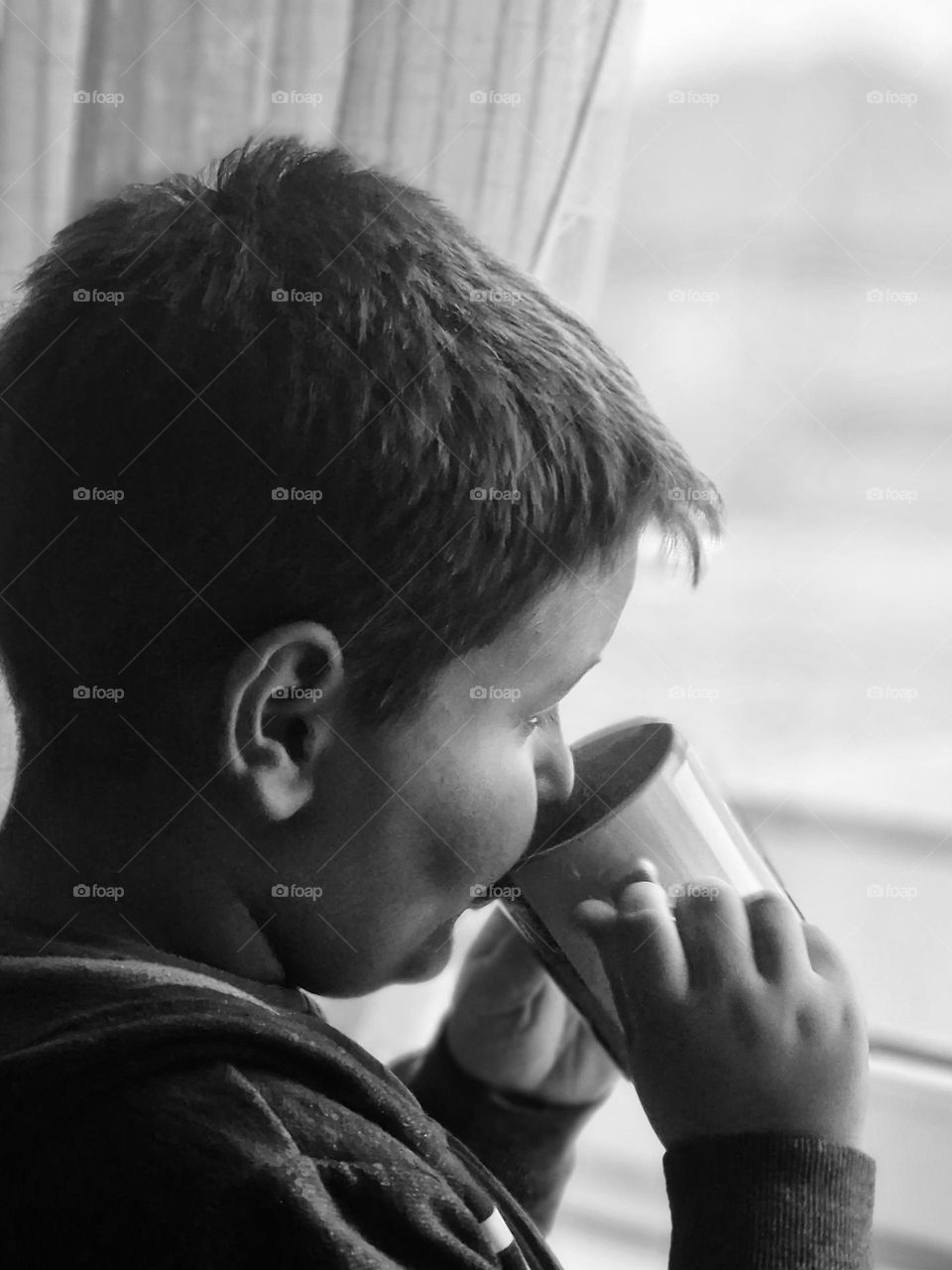 child enjoying a cup of tea in black and white