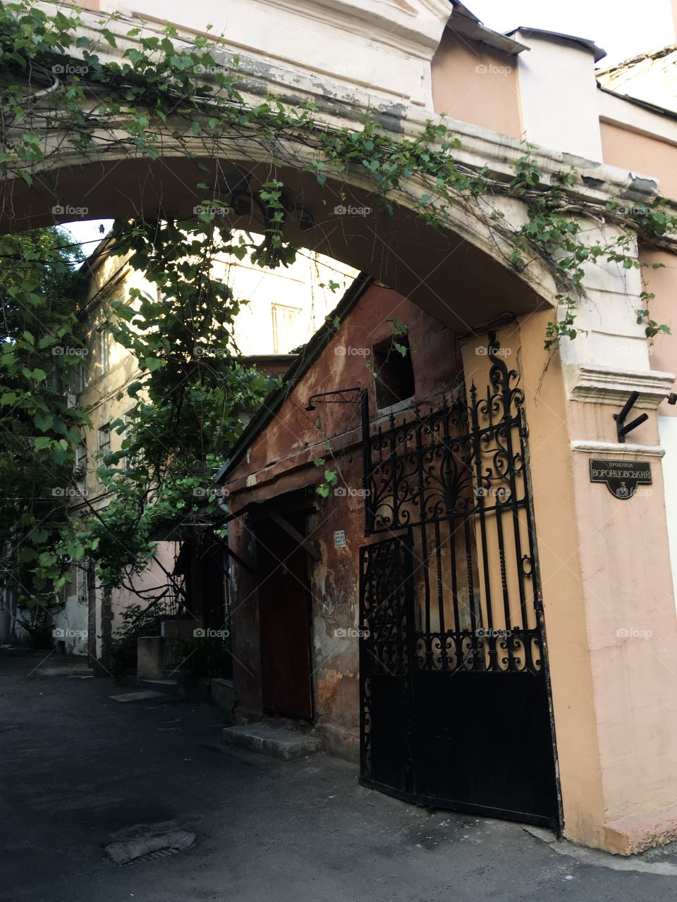The old part of Odessa city, Ukraine. The 29th of May, 2019, evening. The Vorontsov line, the yard entrance, arch with metal gates.