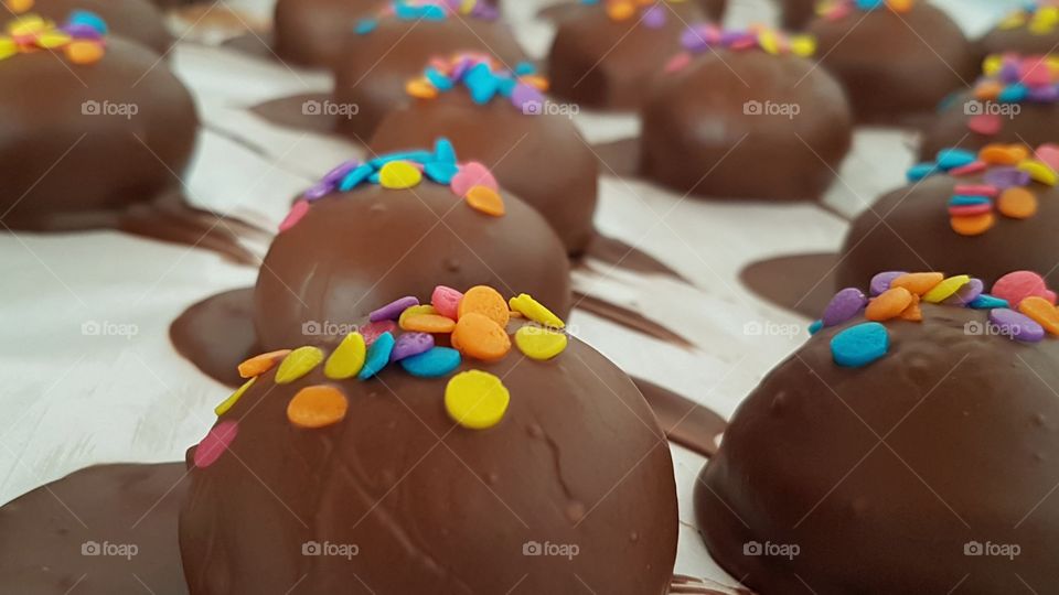 bombom de doce de leite cremoso decorado com bolinhas de chocolate coloridas.Delicioso para festas infantis