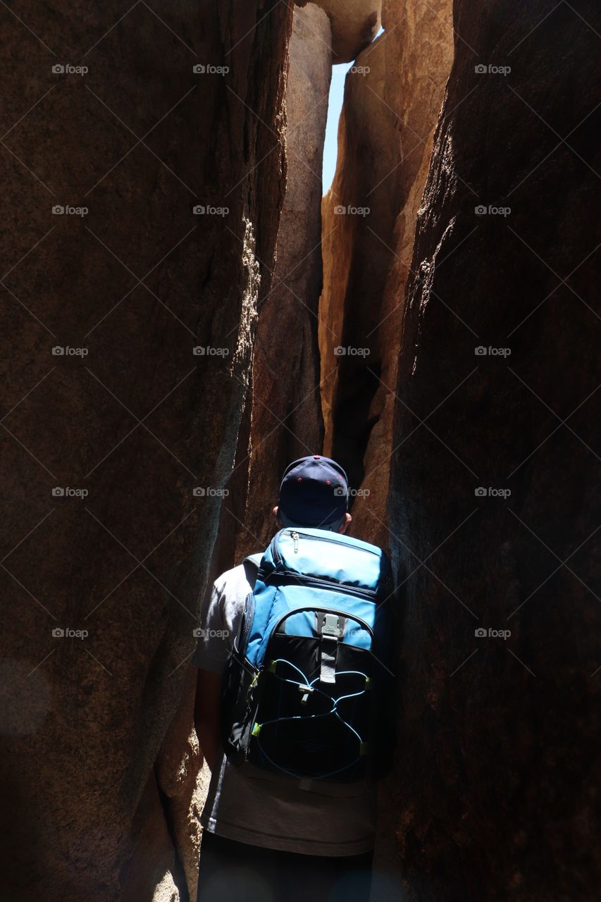 squeezing through a tight canyon at Joshua Tree National park
