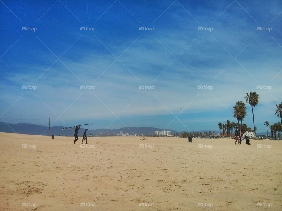 Surfers walking on the beach 