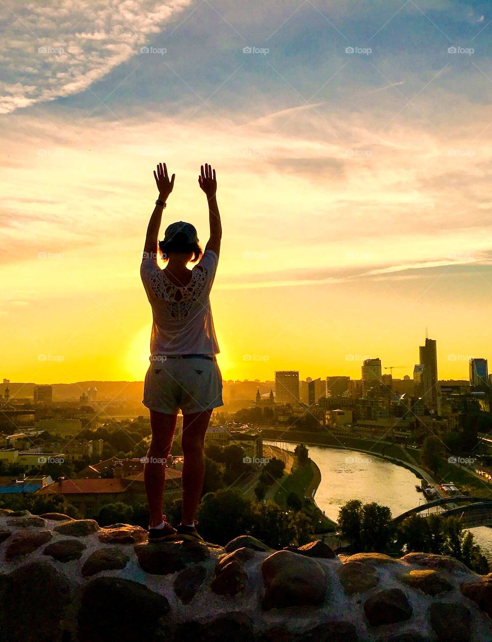 Silhouette of girl standing over the city of Vilnius. 