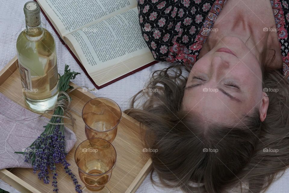 A woman having a rest from above, picnic, a book 