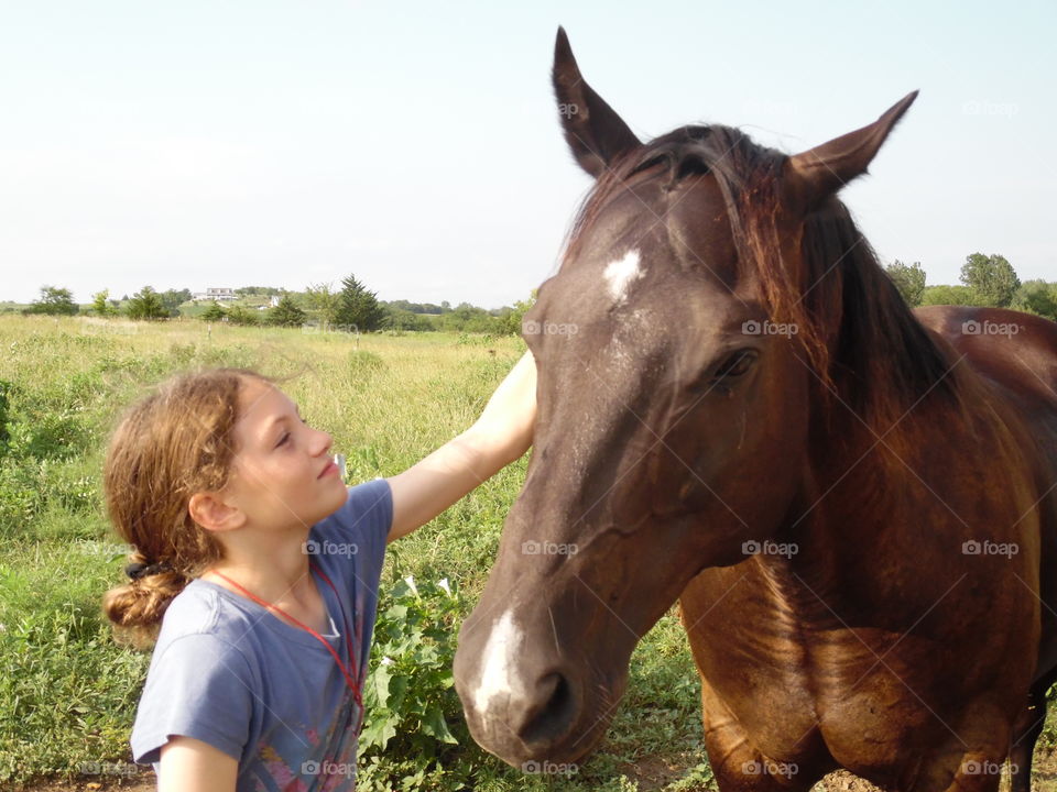 Cute girl standing with horse