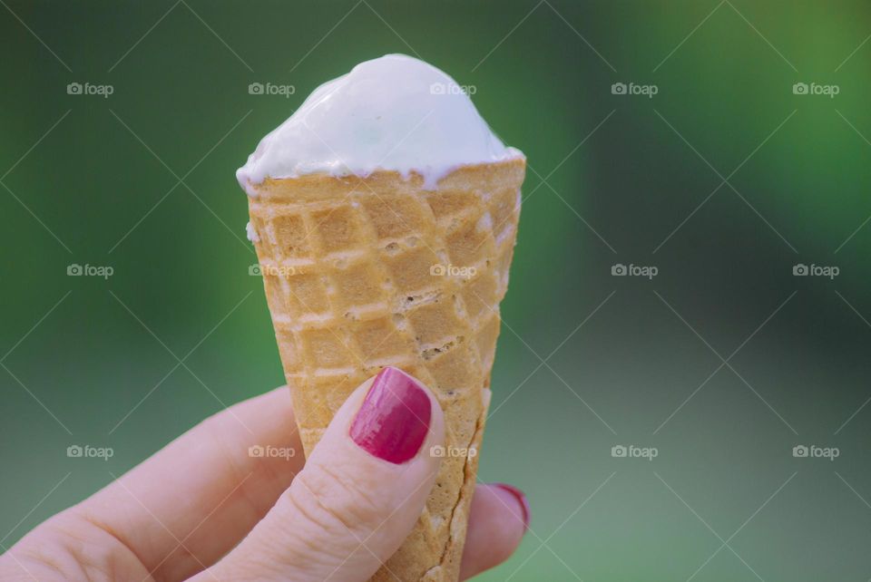 a woman holds ice cream in her hand