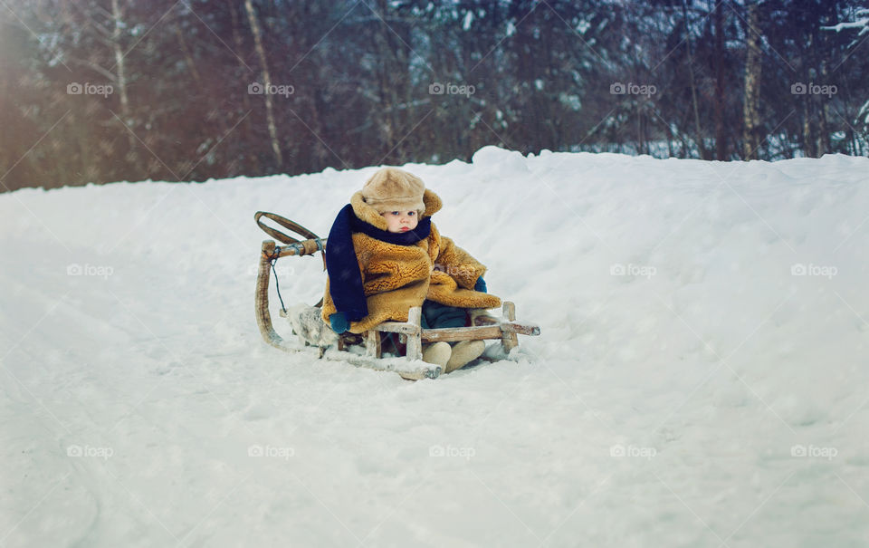 on a sled in a fur coat